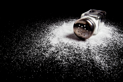 A spilled salt shaker on black.